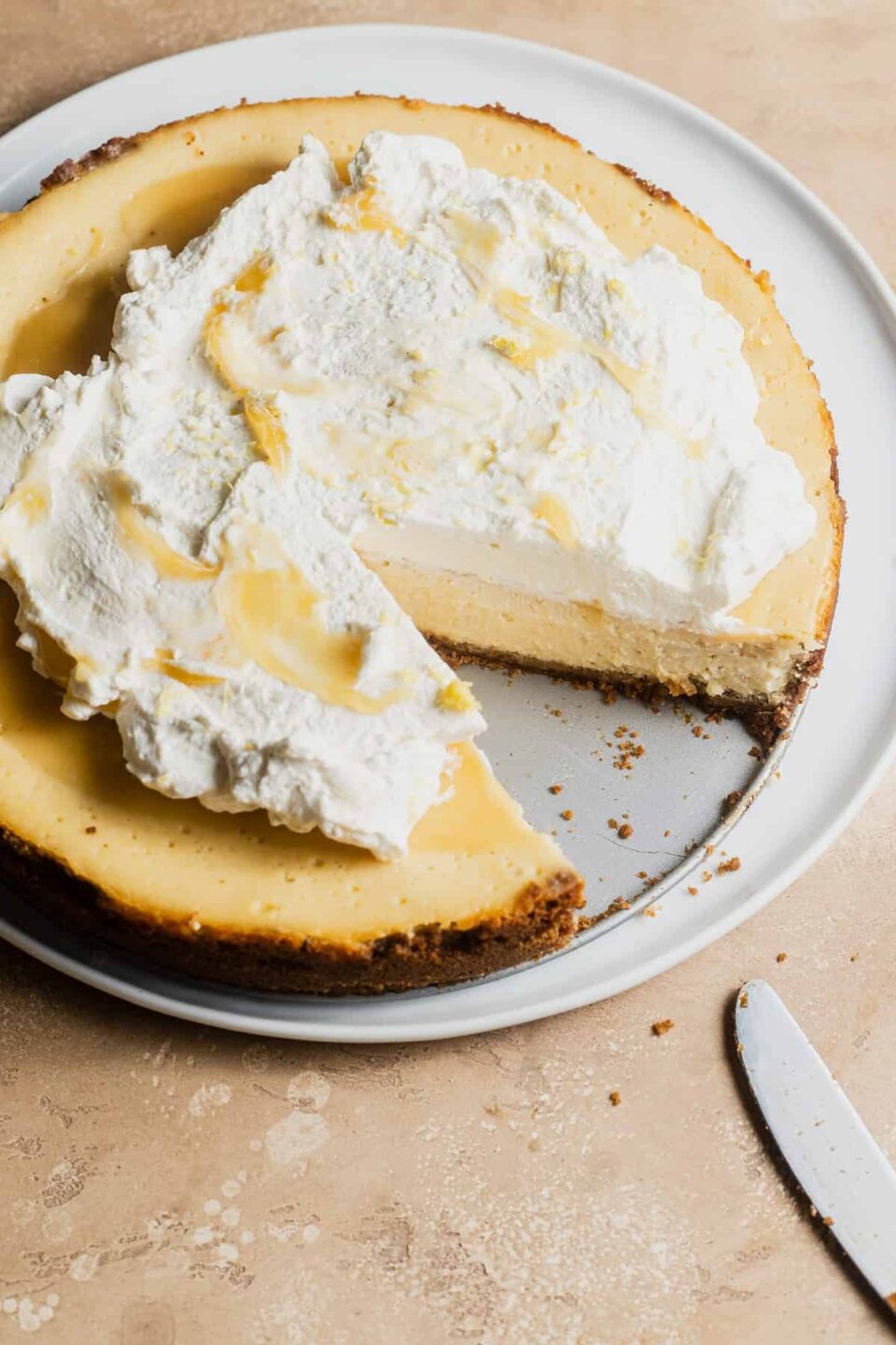 Lemon gingersnap cheesecake with lemon curd and whipped cream.