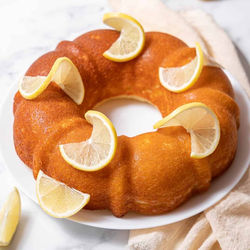 lemon yogurt cake decorated with lemon slices.