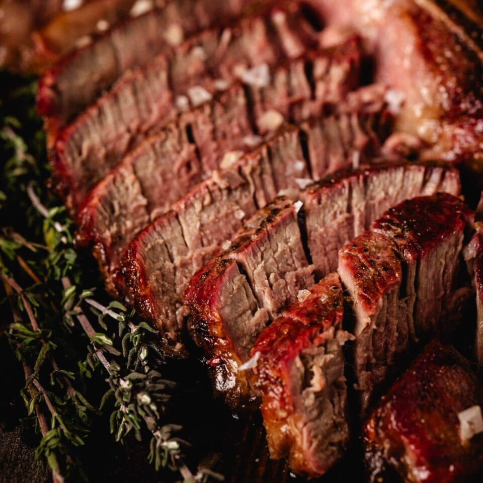 Sliced porterhouse steak with thyme sprigs.