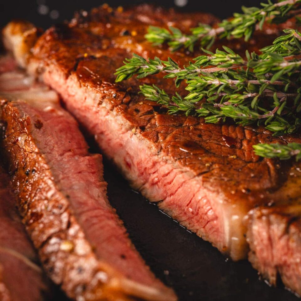 Sliced steak with garnish.