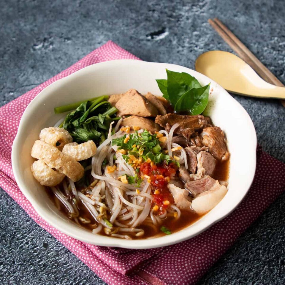 a bowl of boat noodles on pink napkin