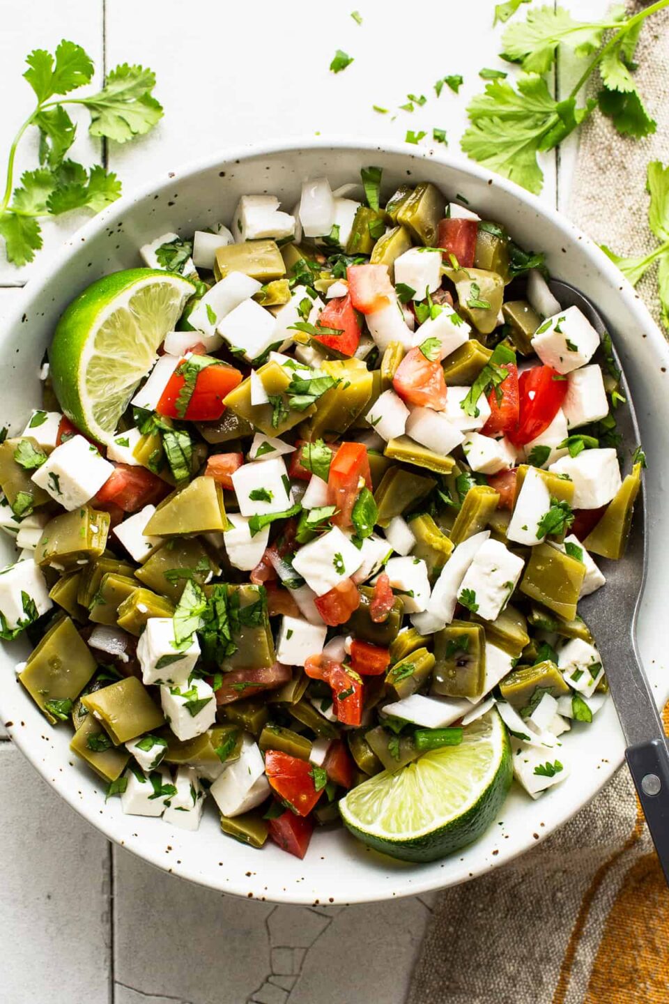 Ensalada de nopales served in a bowl with lime wedge