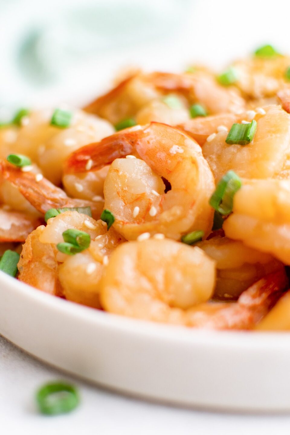 A white plate filled with cooked hibachi shrimp that