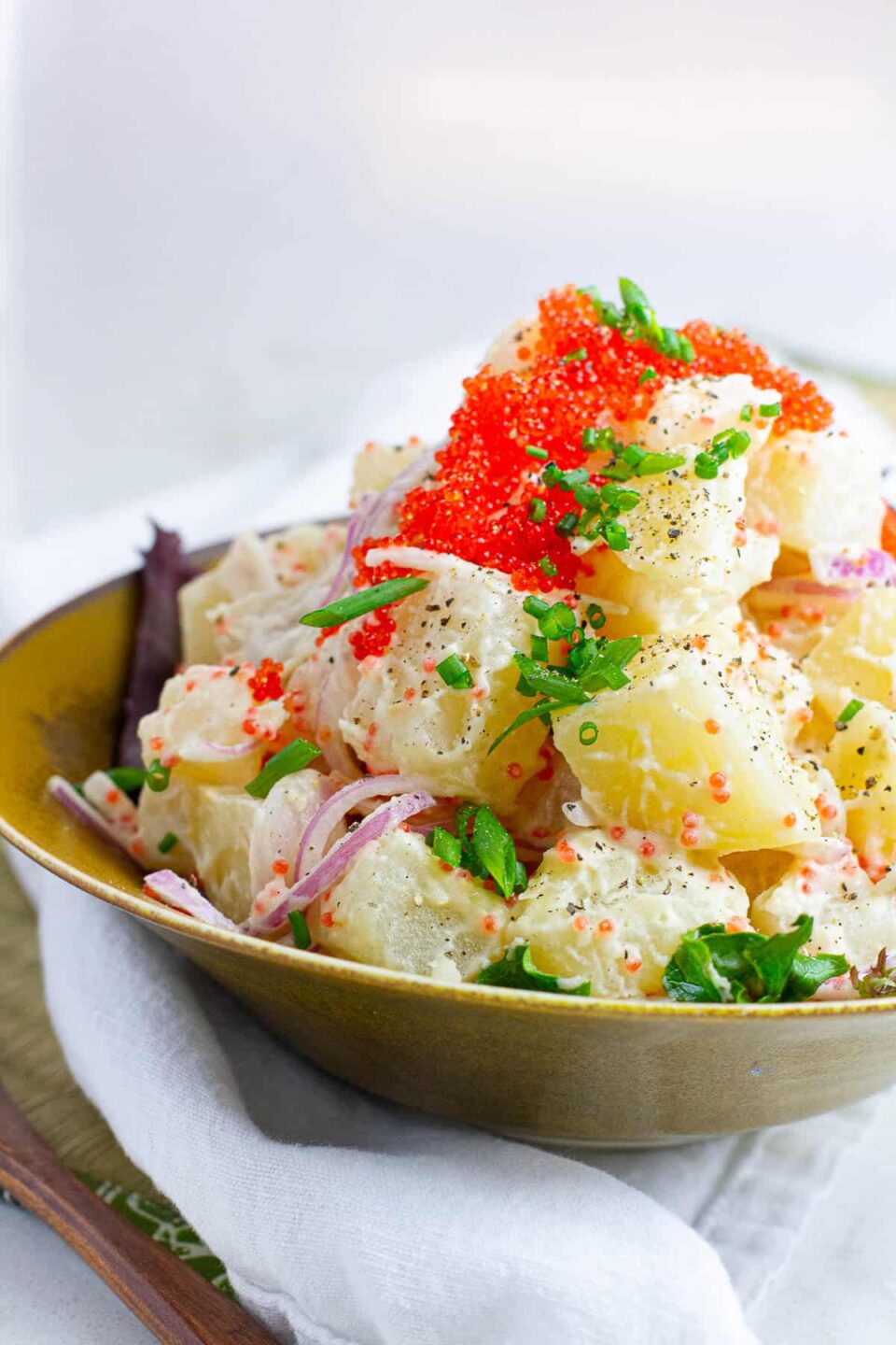 Side view of Japanese potato salad with tobiko , served in a bowl.