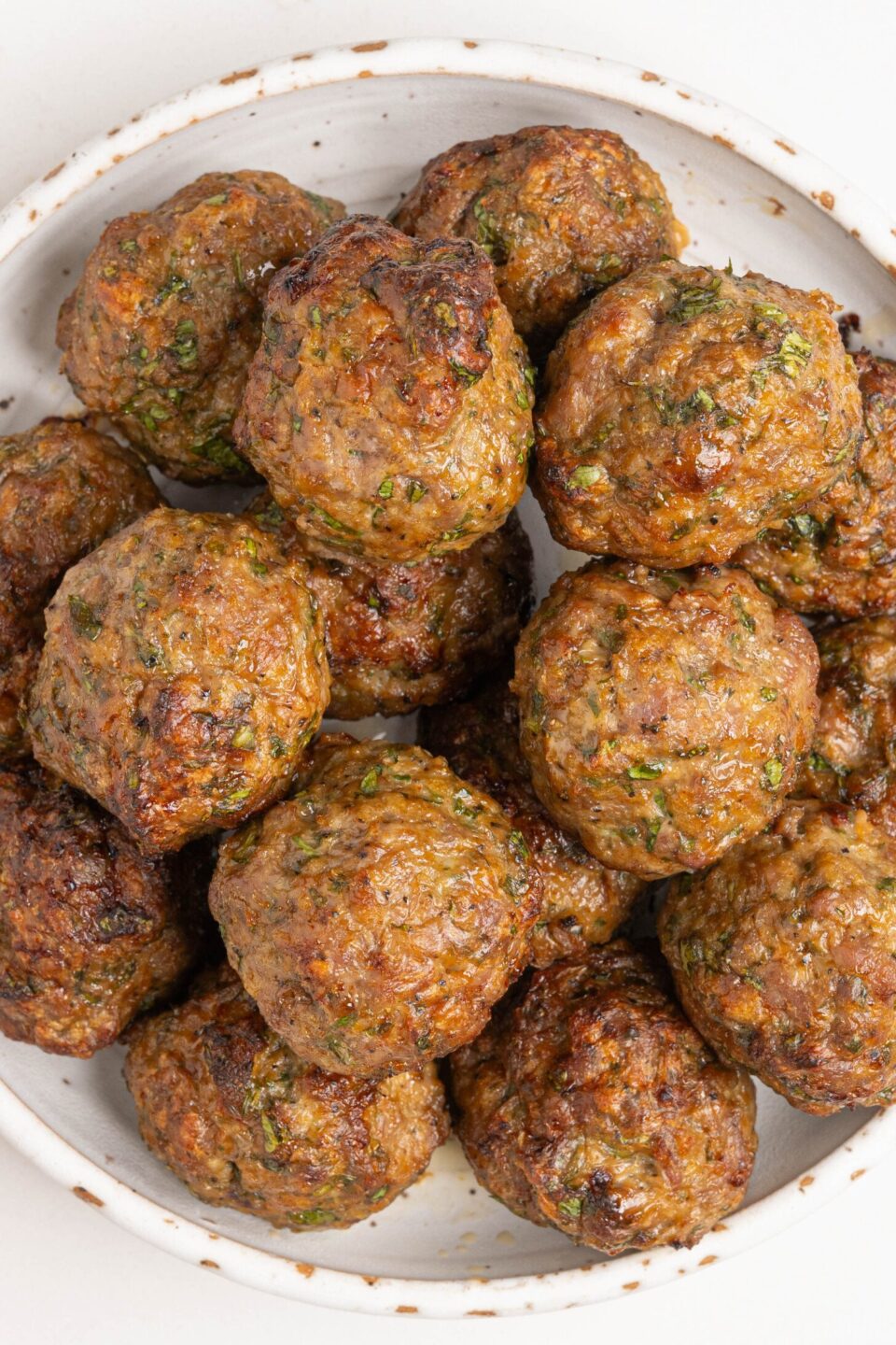 A bowl of baked lamb meatballs.