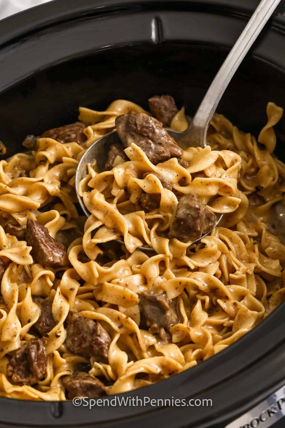 taking a spoonfull of Crock Pot Beef and Noodles out of the pot