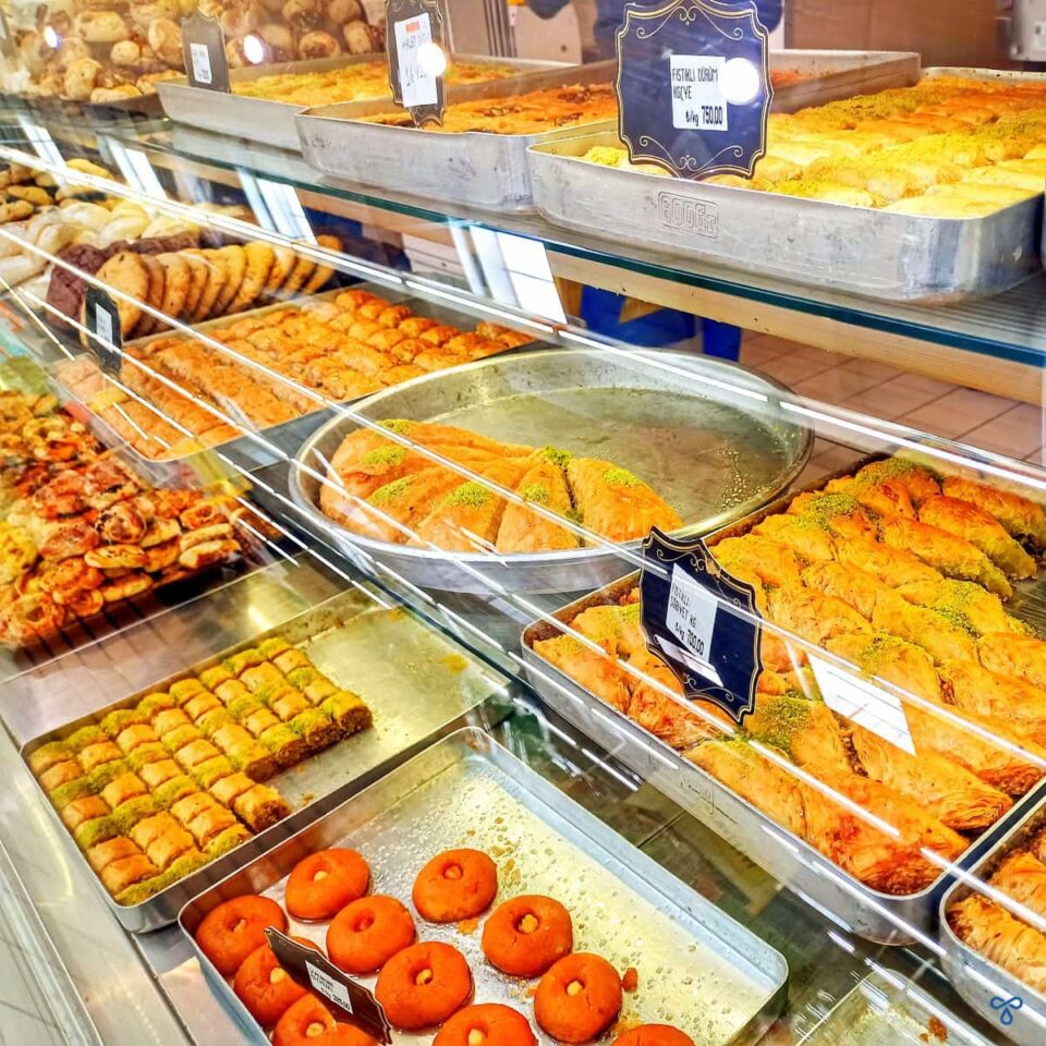 A variety of Turkish desserts in a glass display.