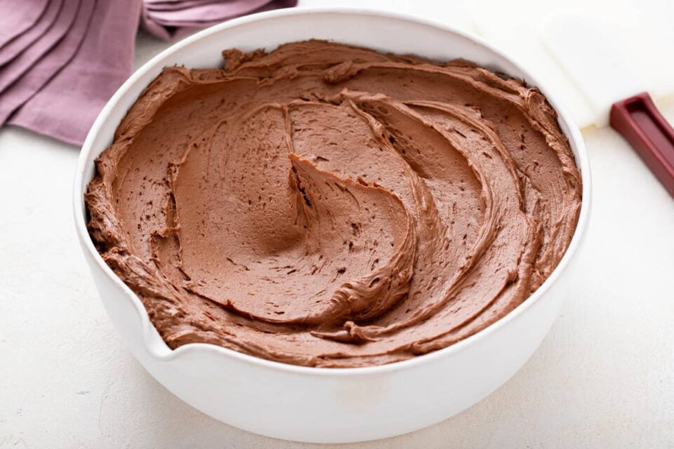 White bowl filled with chocolate buttercream frosting.