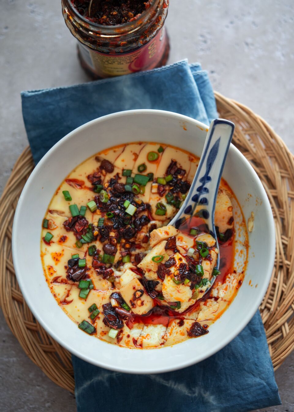 Chinese steamed egg in a bowl with a spoon.